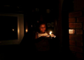 在轮流停电期间，一个孩子举着蜡烛走路。