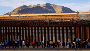 Migrants queue near the border fence,